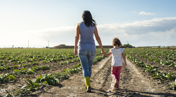 Mother and daughter walking on dirt road